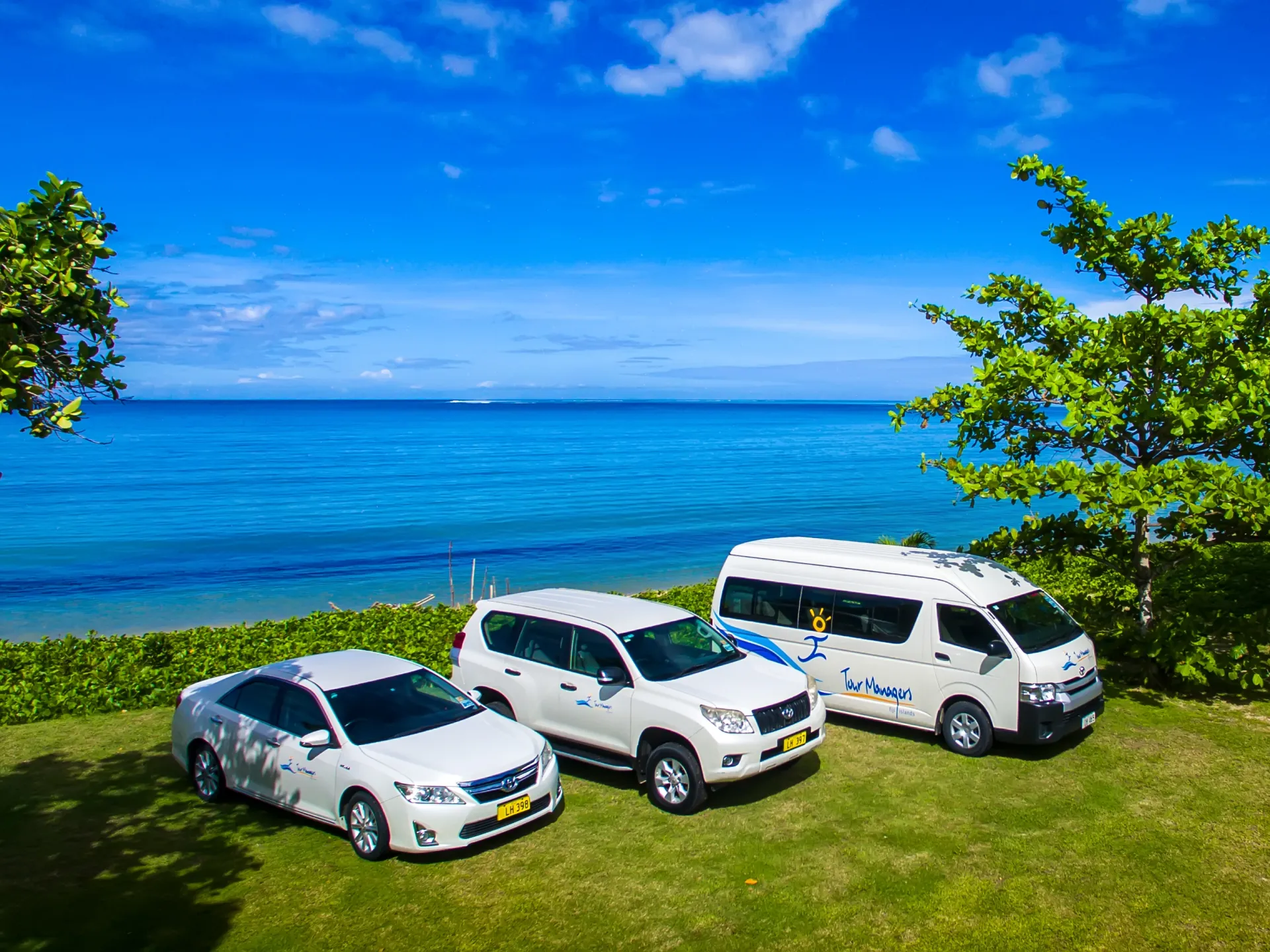 Tour Managers Fiji cars, SUV and passenger van beside the Fiji coast